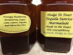 Image may contain: food, text that says "Oranges, Blueberries, strawberries, Sugar, Lime, Lemon, Tequila. Best before Dec 2021. Hedge Το Toast Tequila Sunrise Marmalade Made in the Dales Tel; 07974568009 facebook: Hedge to Toa"